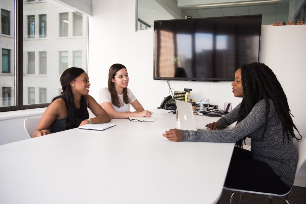 Two women asking another job interview questions in an office